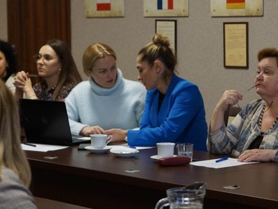 uczestnicy spotkania prowadzą dyskusję przy stole w sali konferencyjnej