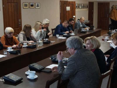 uczestnicy spotkania prowadzą dyskusję przy stole w sali konferencyjnej