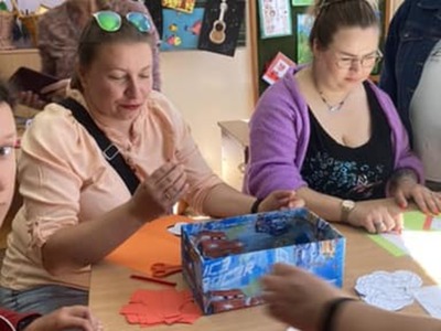 rodzice zaangażowani w zajęcia siedzą przy stole