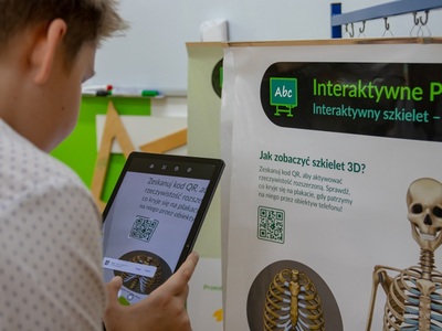 wychowanek SOSW w Węgorzewie skanujący kod QR do tableta z tablicy do tego przeznaczonej