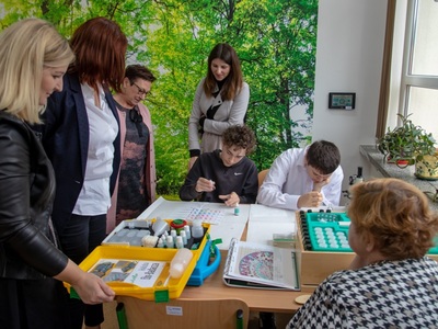 na zdjęciu wychowankowie SOSW w Węgorzewie robiący doświadczenia wokół obserwują to zaproszeni goście 