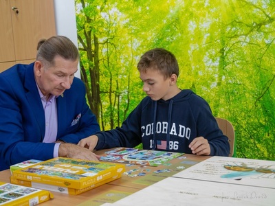 przewodniczący Komisji ds. Społecznych i Finansów Eugeniusz Pieczul wraz z wychowankiem SOSW w Węgorzewie układa puzzle