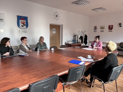 rada Działalności Pożytku Publicznego przy stole w sali konferencyjnej Starostwa Powiatowego w Węgorzewie w tle herby gmin