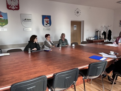 rada Działalności Pożytku Publicznego przy stole w sali konferencyjnej Starostwa Powiatowego w Węgorzewie w tle herby gmin