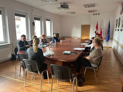 Członkowie Powiatowej Rady Rynku w Węgorzewie siedzą przy stole w sali konferencyjnej Starostwa Powiatowego w Węgorzewie