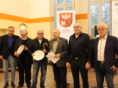 na zdjęciu część zawodników, w tle logo samorządu województwa warmińsko-mazurskiego
