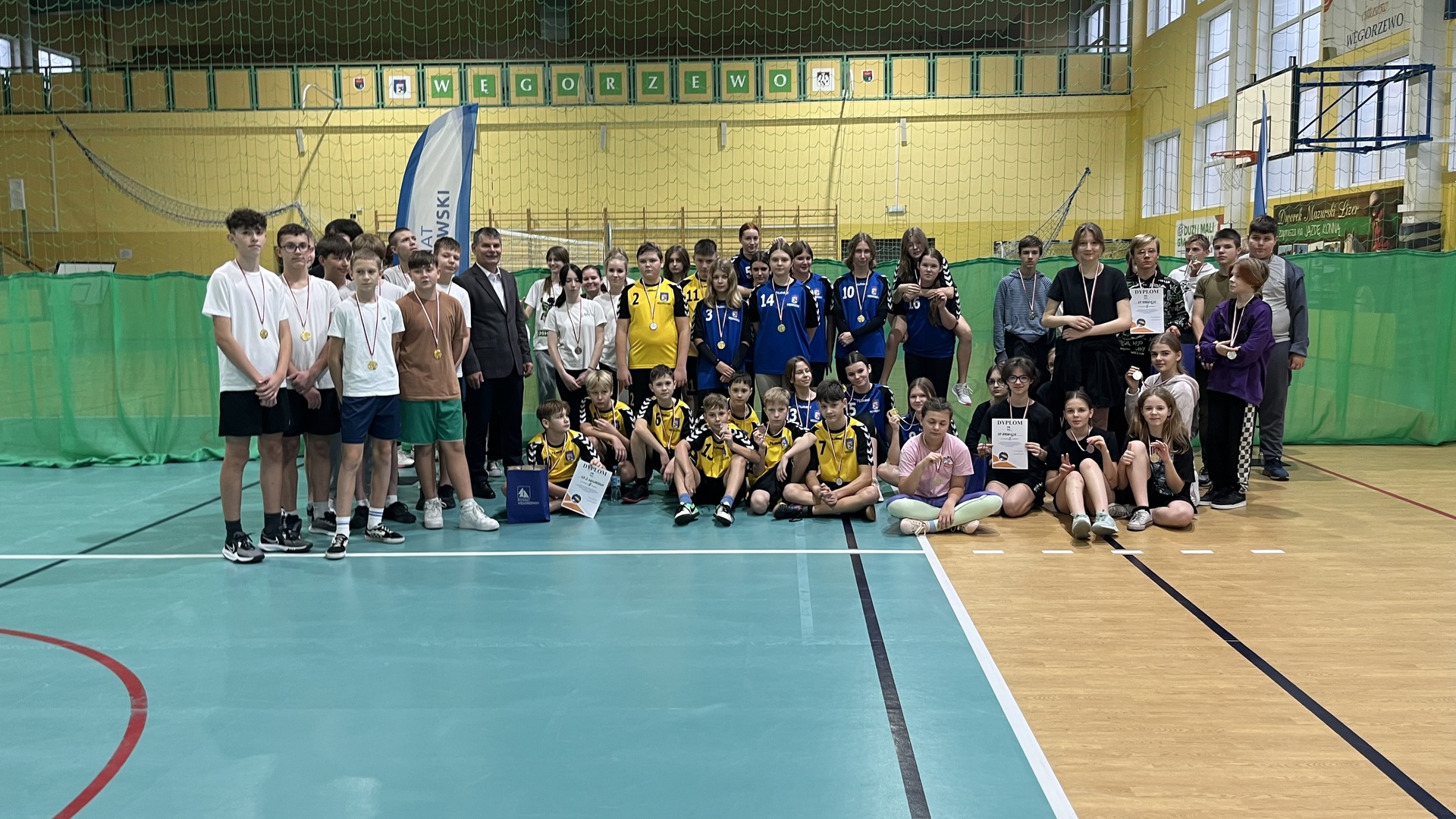zdjęcie grupowe wszyscy zawodnicy biorący udział w zawodach wraz z trenerami oraz wicestarostą węgorzewskim