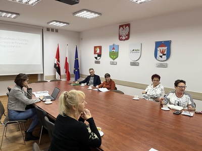 członkowie Rady siedzą przy stole w Sali konferencyjnej