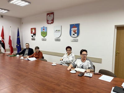 członkowie Rady siedzą przy stole w Sali konferencyjnej