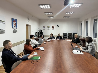 członkowie Rady siedzą przy stole w Sali konferencyjnej
