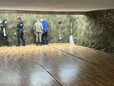zawodnicy sprawdzają tarczę wraz z sędzią zawodów