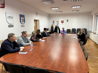 członkowie Rady Działalności Pożytku Publicznego Powiatu Węgorzewskiego siedzą przy stole w sali konferencyjnej - trwają obrady