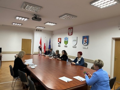 członkowie Rady Działalności Pożytku Publicznego Powiatu Węgorzewskiego siedzą przy stole w sali konferencyjnej - trwają obrady 