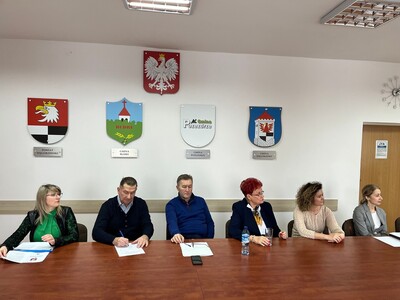 członkowie Rady Działalności Pożytku Publicznego Powiatu Węgorzewskiego siedzą przy stole w sali konferencyjnej - trwają obrady 