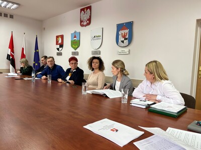członkowie Rady Działalności Pożytku Publicznego Powiatu Węgorzewskiego siedzą przy stole w sali konferencyjnej - trwają obrady 