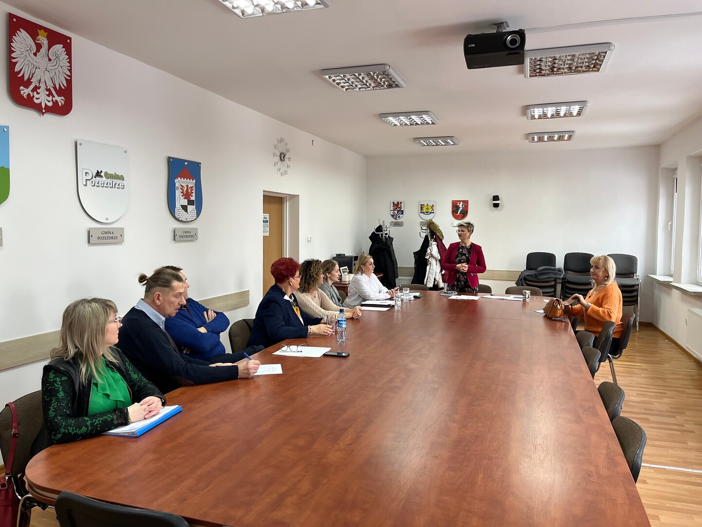 członkowie Rady Działalności Pożytku Publicznego Powiatu Węgorzewskiego siedzą przy stole w sali konferencyjnej - trwają obrady 