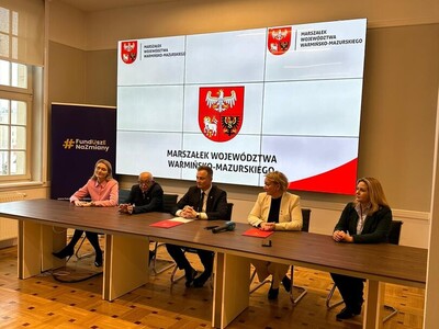 uroczyste podpisanie Porozumienia Terytorialnego  - Zarząd Województwa i Prezes Stowarzyszenia siedzą przy stole przed oficjalnym