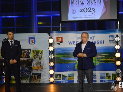Burmistrz Węgorzewa wraz z Wicestarostą na scenie w tle banery
