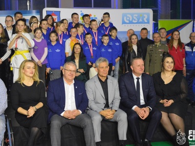 zdjęcie grupowe w tle dzieci, na pierwszym planie goście