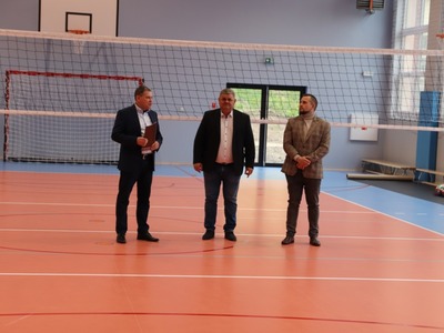 na płycie boiska stoją od prawej Kierownik budowy, Prezes firmy wykonującej budowę sali oraz Dyrektor ZSZ w Węgorzewie