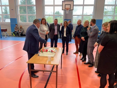 Dyrektor ZSZ w Węgorzewie kroi tort dookoła zaproszeni goście