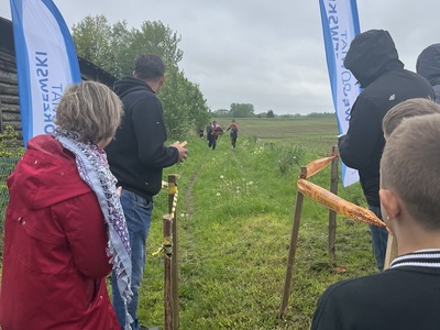 na zdjęci zawodnicy dobiegają do mety po obu stronach trenerzy w tle windery powiatu węgorzewskiego