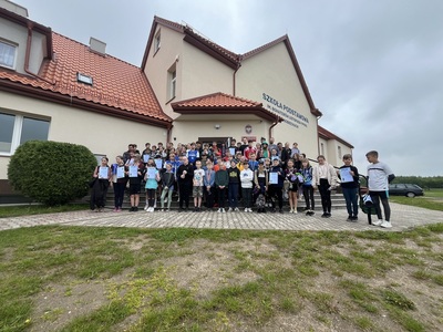 na zdjęciu wszyscy zawodnicy w tle budynek szkoły