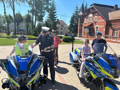 na zdjęciu dwa motory policyjne, na których siedzą dzieci