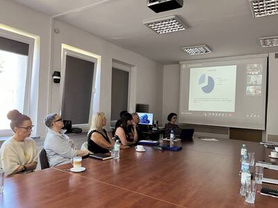 uczestnicy spotkania siedzą przy stole w sali konferencyjnej 