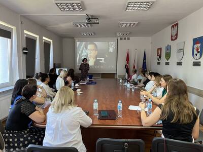 uczestnicy spotkania siedzą przy stole w sali konferencyjnej 