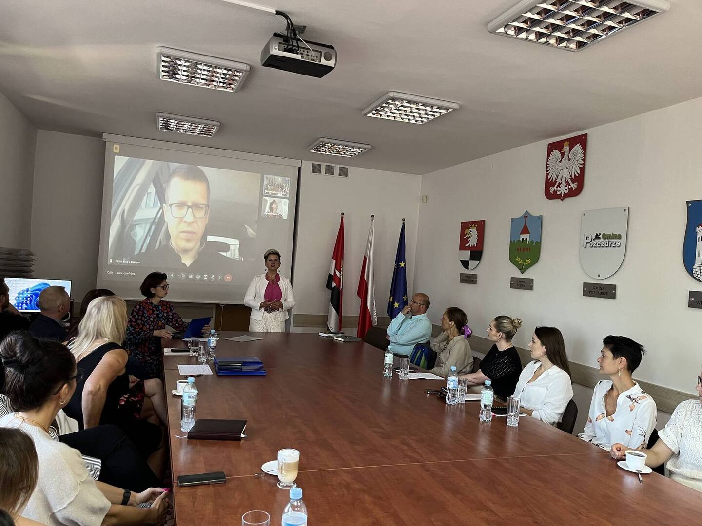 uczestnicy spotkania siedzą przy stole w sali konferencyjnej 