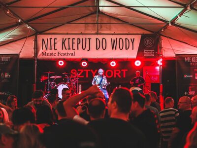 na zdjęciu artyści na scenie występujący przed publicznością