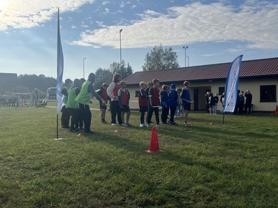 na zdjęciu zawodnicy gotowi do startu, w tle budynek 