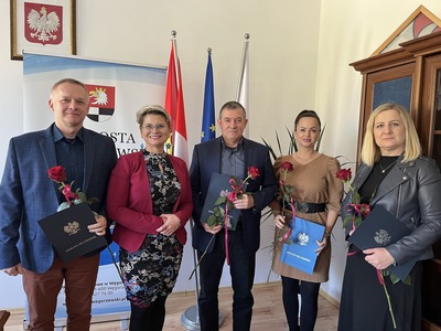 Alicja Rymszewicz Starosta Węgorzewski wraz z Dyrektorami Placówek Oświatowych z Powiatu Węgorzewskiego, w tle flagi
