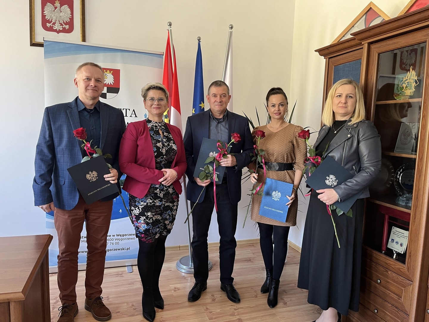 Alicja Rymszewicz Starosta Węgorzewski wraz z Dyrektorami Placówek Oświatowych z Powiatu Węgorzewskiego, w tle flagi