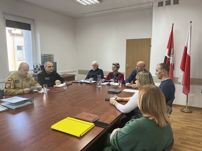 na zdjęciu widzimy członków komisji oraz członków PZZK przy stole na sali konferencyjnej Starostwa Powiatowego w Węgorzewie, w tle flagi