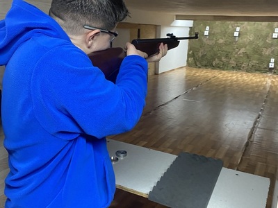 zawodniczka podczas oddawania strzału, w tle tarcza