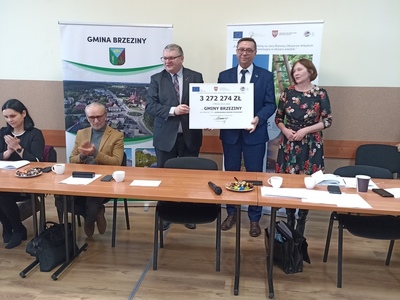 wójt Gminy Brzeziny pokazuje czek opiewający na wartość dofinansowania