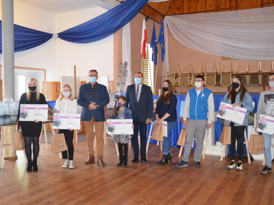 zdjęcia w sali OSP od lewej strony ubrana na czarno Justyna Karolak zdobywczyni III miejsca, następnie Julia Pietrzak zdobywczyni I miejsca, ubrana w bluzkę koloru białego oraz spodnie koloru czarnego, trzecia osoba od lewej Wójt Gminy Brzeziny Marek Cieślarczyk ubrany w marynarkę koloru granatowego oraz spodnie w kolorze musztardowym, Gabriela Kupajczyk oraz Prezes Zarządu Stowarzyszenia " Długosz Królewski" Zbigniew Słodowy wraz z laureatami konkursu.