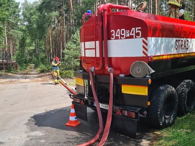 samochody pożarnicze w lesie, strażacy z wężami