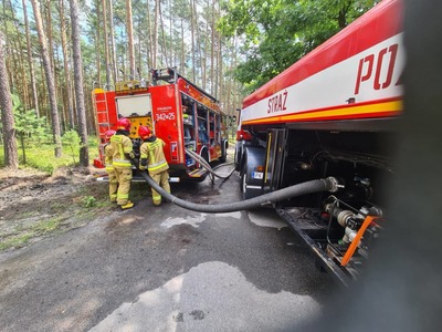 samochody pożarnicze w lesie, strażacy z wężami