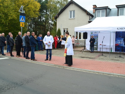 Ksiądz Wikary Andrzej Szulc święci drogę, w tle zaproszeni goście