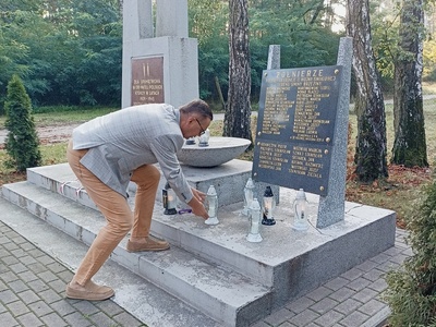 Wójt Gminy Brzeziny zapala znicz na grobie