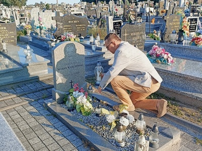 Wójt Gminy Brzeziny zapala znicz na grobie