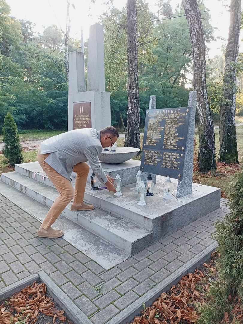 Wójt Gminy Brzeziny zapala znicz na grobie