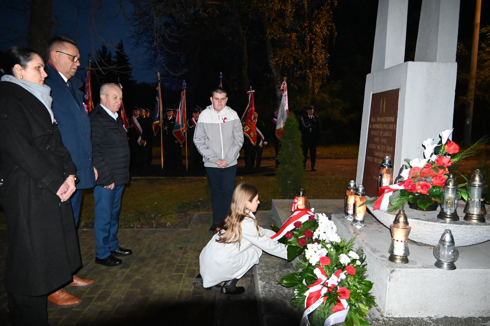 władze gminy składają kwiaty przed pomnikiem 