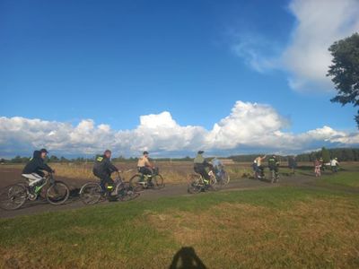 Zdjęcie przedstawia mieszkańców sołectwa Łomów jadących rowerami.