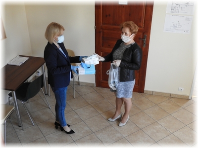 Kierownik GOPS Orchowo Iwona Mietlicka przekazuje zestaw maseczek oraz rękawic ochronnych dla podopiecznych w związku z zabezpieczeniem przed rozprzestrzenianiem się epidemii koronawirusa COVID 19 
