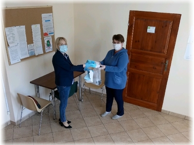 Kierownik GOPS Orchowo Iwona Mietlicka przekazuje zestaw maseczek oraz rękawic ochronnych dla podopiecznych w związku z zabezpieczeniem przed rozprzestrzenianiem się epidemii koronawirusa COVID 19 