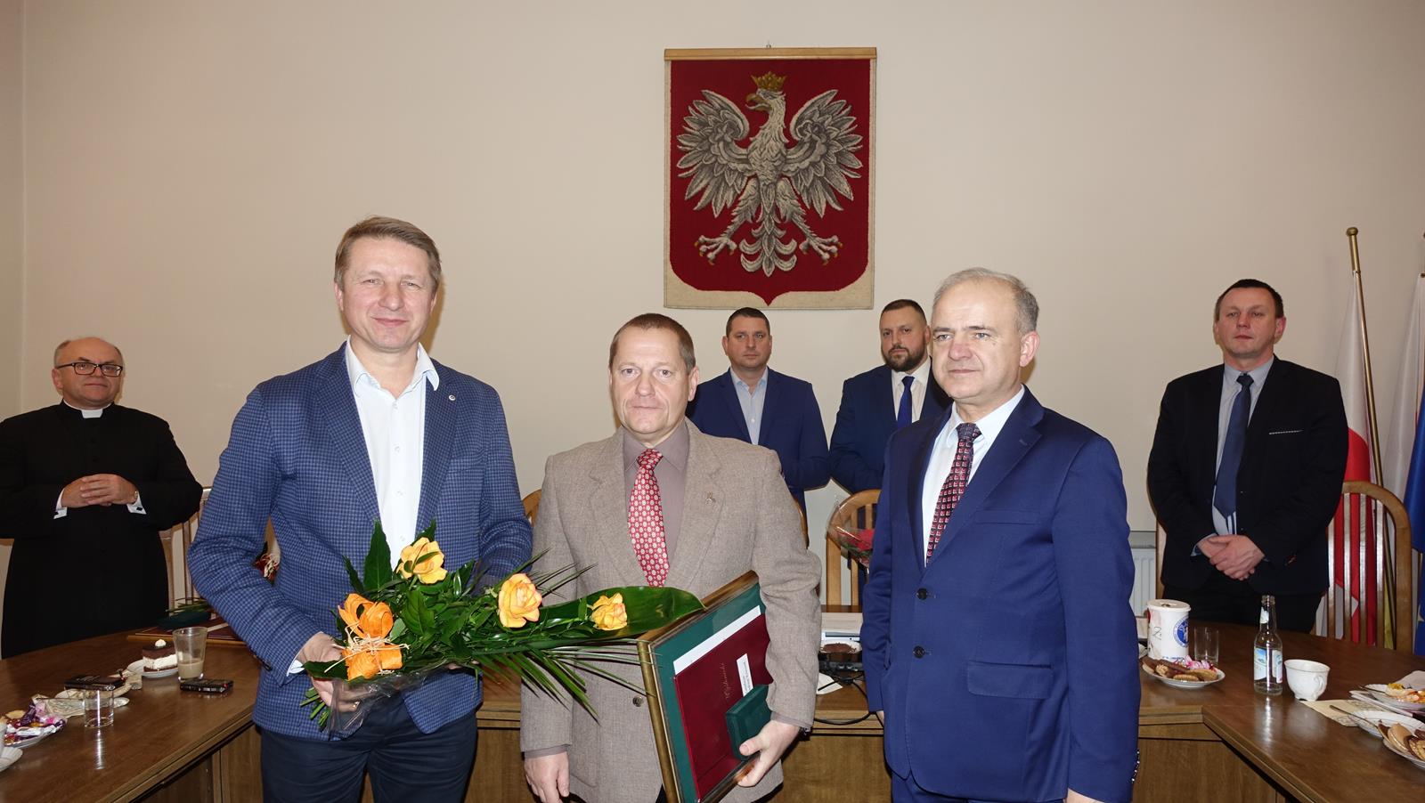 Na zdjęciu widoczni przedstawiciele Powiatu Myślenickiego, wraz z laureatem, w tle wisi Godło Polski